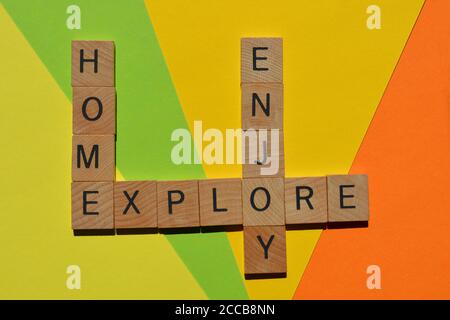 Home, Enjoy, Explore, words in wooden alphabet letters in crossword form isolated on colourful background Stock Photo