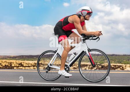 Triathlon cyclist man cycling racing on road bike on ironman competition racing against time. Triathlete training bicycle workout for triathlon race Stock Photo
