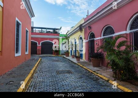 Colorfully painted houses on a narrow cobblestone street in the historic colonial city of Old San Juan, Puerto Rico. Stock Photo