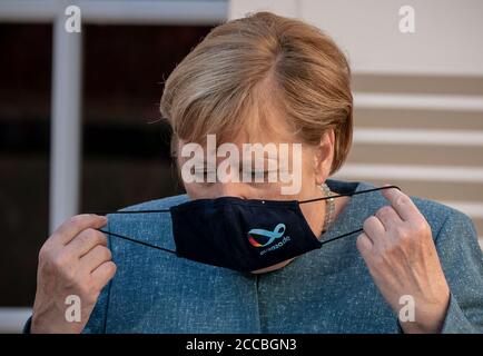 Bormes Les Mimosas, France. 20th Aug, 2020. German Chancellor Angela Merkel (CDU) takes off her mask at the beginning of the press conference with French President Macron at the summer residence of the Head of State, the Fort de Bregancon. The former fortress is located on a rock on the Mediterranean coast near Toulon. Credit: Michael Kappeler/dpa/Alamy Live News Stock Photo