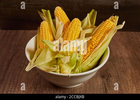 Fresh Corn on the cob in a white bowl on the table Stock Photo