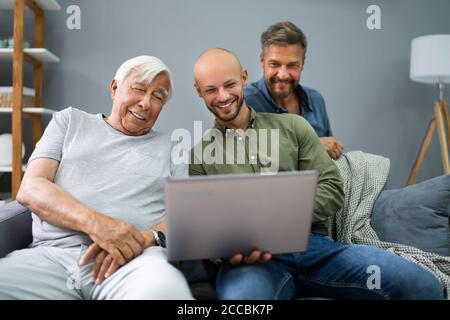 Happy Three Generation Men Using Laptop Computer Stock Photo