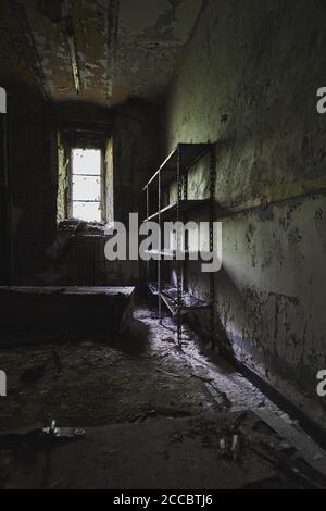 Destroyed room in abandoned building. Sun rays light up messy ...