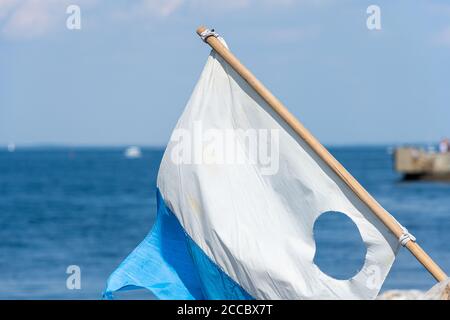 A closeup picture of a blue and white dive flag. Blue ocean in the background Stock Photo