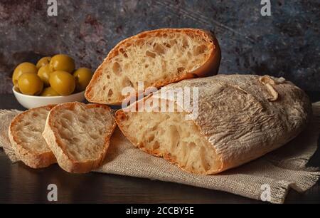 Ciabatta. Fresh italian ciabatta bread with herbs, olive oil and olives, copy space. Stock Photo