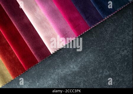 Color gradients of velvet samples on fabric swatch placed on a dark stone table with copy space Stock Photo