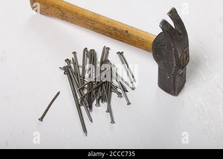 An old hammer and a handful of nails. On white background. Stock Photo