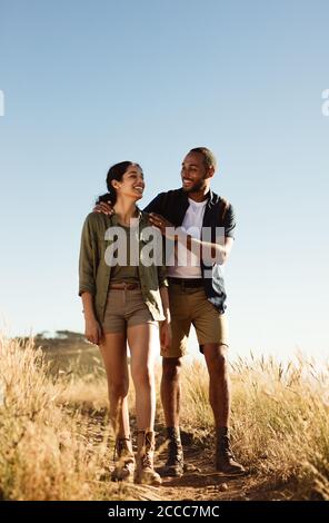 Portrait of a man and woman enjoying hiking. Cheerful couple walking together on a rugged hiking trail. Stock Photo