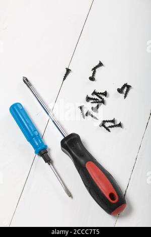 Two screwdrivers and a handful of screws. On white background. Stock Photo