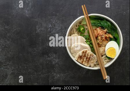 Miso Ramen Asian noodles with egg, chicken, and pak choi cabbage in bowl. Japanese cuisine. 