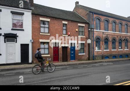 Terraced houses and the Hudson and Middleton Sutherland Works in Normacot Road, Longton, Stoke on Trent, Staffordshire Stock Photo