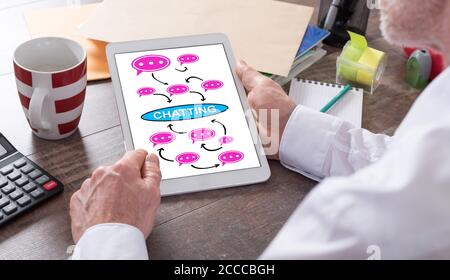 Chatting concept shown on a tablet held by a man Stock Photo
