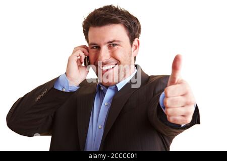 Satisfied businessman is talking on his cell phone and showing thumbs up Stock Photo