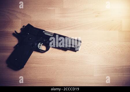Security and safety concept : black gun on a wooden table Stock Photo