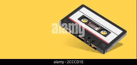 Old black audio tape compact cassette record isolated on orange background Stock Photo