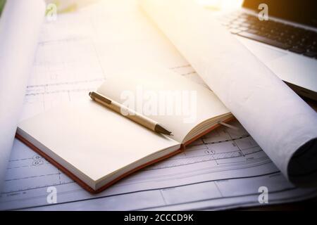 architect workplace background : notebook on blueprints for architectural plan with laptop on table in architect man working office Stock Photo