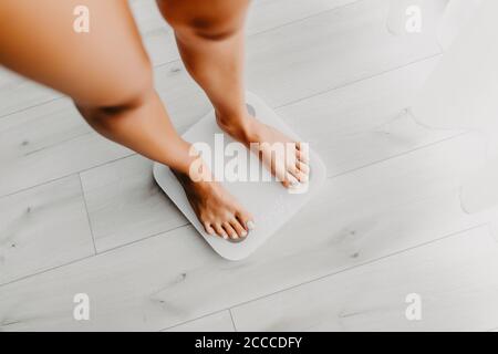 Feet of woman on weighting scale at home Stock Photo