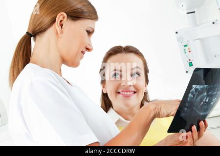 Dentist shows a patient her x-ray Stock Photo