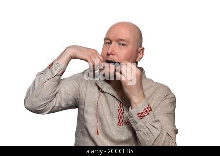 Bald man in national dress plays the Jew's harp Stock Photo