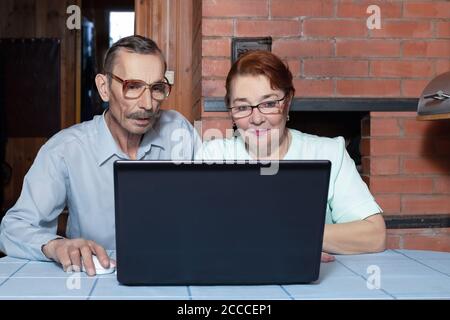 Senior couple and modern technologies. Internet surfing with laptop Stock Photo