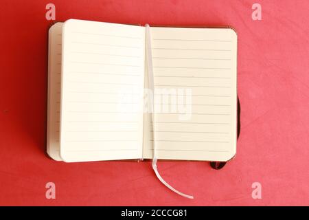 Open empty notebook on a red background Stock Photo
