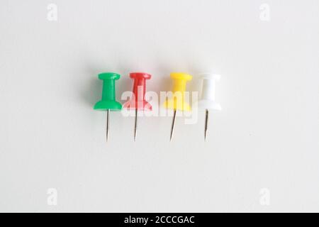 Plastic push pins on a white surface Stock Photo