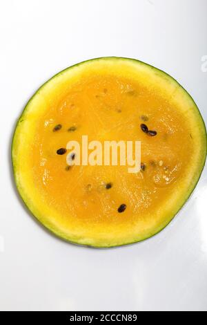 Slice of yellow watermelon on a white background. Stock Photo