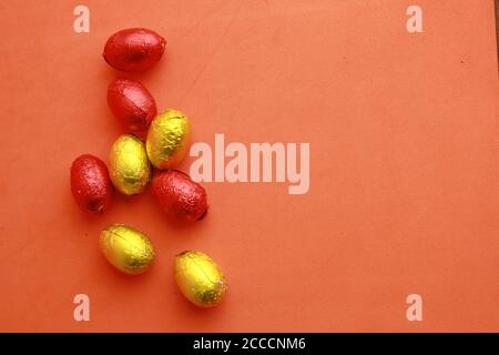 Closeup shot of chocolate Easter eggs wrapped in yellow and red paper Stock Photo