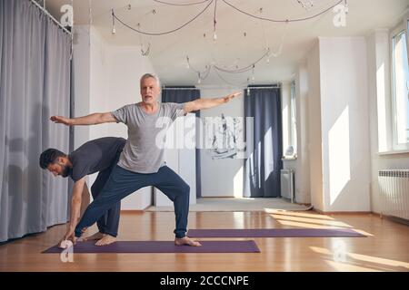Beginner yogi practicing yoga in a gym Stock Photo