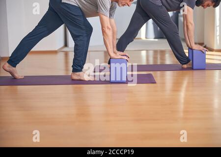 Serious man and his coach doing a stretching exercise Stock Photo