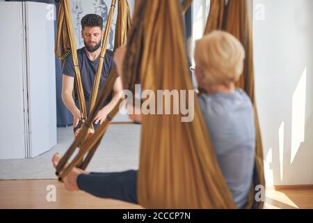 Two barefoot Caucasian people practicing aerial yoga Stock Photo