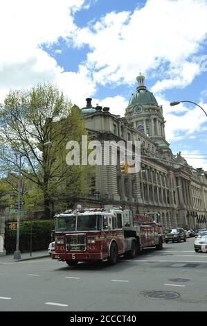 Fire Department New York fire truck driving past former New York City Police Headquarters on Centre Street, New York, NY, USA Stock Photo