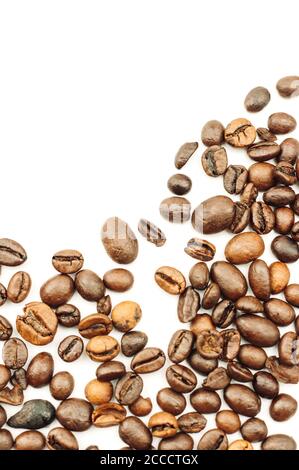 Coffee beans are scattered over the surface on a blank white background. a handful of brown coffee beans. Coffee background with copy space for Stock Photo