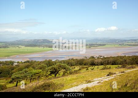 Ariel view from Arnside Knot Cumbria of the rail bridge over the Kent estuary at the  resort of Arnside with the he lake district in the background Stock Photo