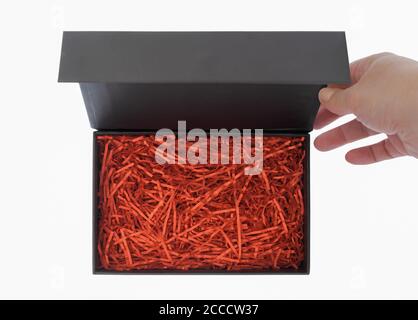 Black box with red filler, the hand opens the lid Stock Photo