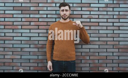 young man hipster holding something small in his hands and smiling. Stock Photo
