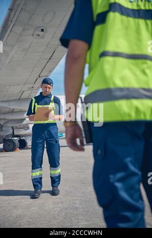 Two aircraft mechanics standing at the aerodrome Stock Photo