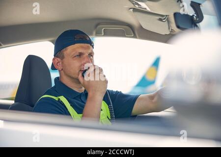 Airport car driver speaking into the microphone Stock Photo