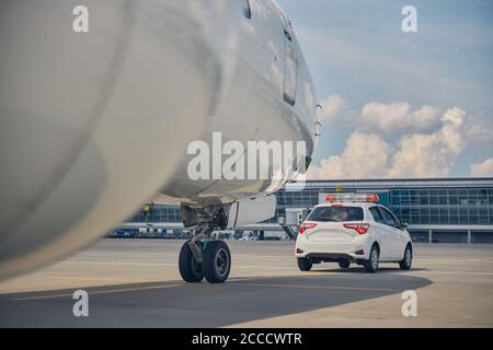 Landed airliner taxing after an airport car Stock Photo