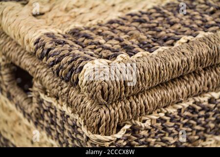Closeup of icker storage basket with hinged lid, covered container, made of natural bamboo, isolated on white background, shallow depth of field Stock Photo