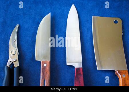 Kitchen knives collections on the blue background, tools and instruments for cooking. Stock Photo