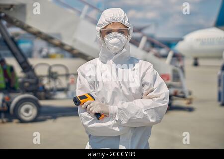 Woman with an infrared thermometer looking at the camera Stock Photo