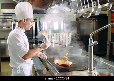 Chef cooking vegetables in wok pan. Shallow dof. Stock Photo