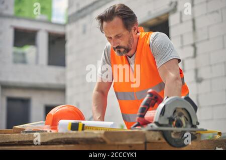 Concentrated serious civil engineer studying construction drawings Stock Photo