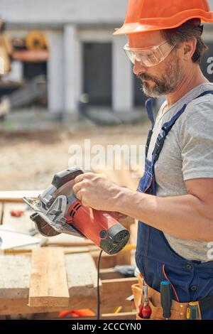 Focused carpenter getting ready for cutting wood Stock Photo