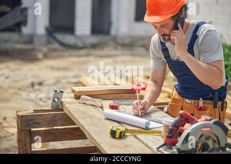 Man in overalls talking on the phone Stock Photo