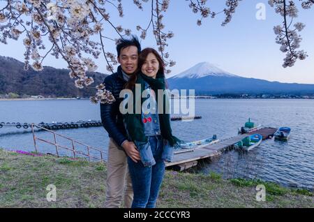 Lovely couple taking photo at Kawaguchiko with Fuji mountain and cherry blossoms view in spring, Japan. Stock Photo