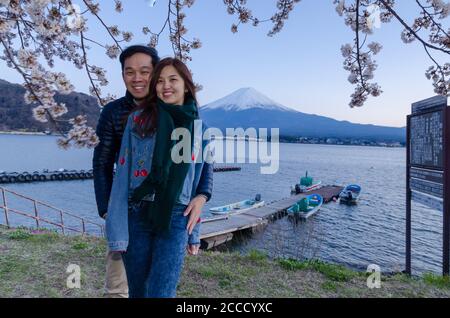 Lovely couple taking photo at Kawaguchiko with Fuji mountain and cherry blossoms view in spring, Japan. Stock Photo