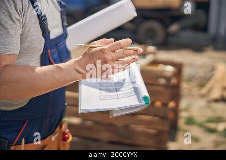 Man in work clothes holding house plans Stock Photo