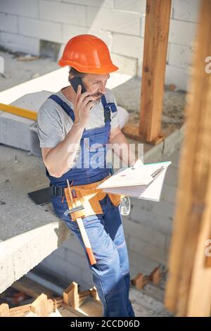 Man in workwear talking on his cellular phone Stock Photo